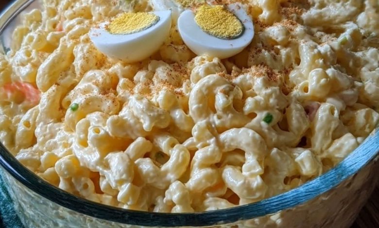 Creamy old-fashioned macaroni salad with hard-boiled eggs in a glass serving bowl