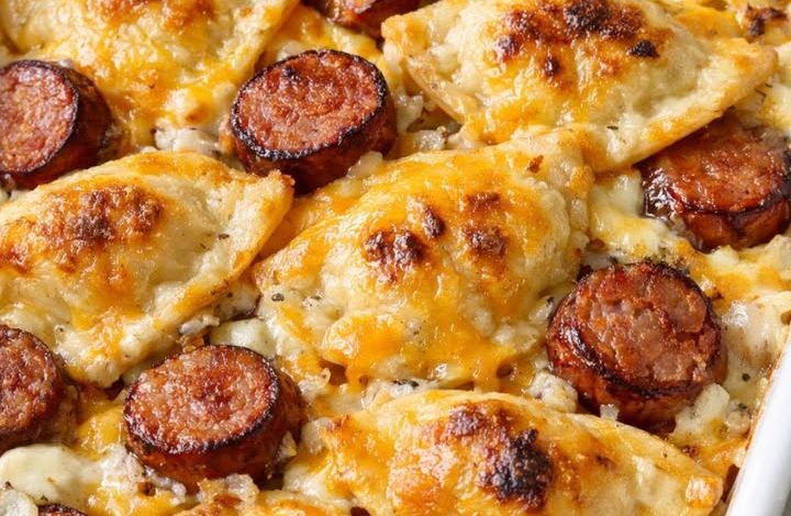 Oven-baked pierogi kielbasa casserole with melted cheese and sliced smoked sausage