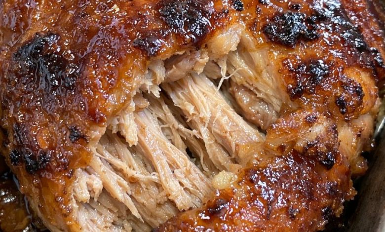 Tender brown sugar garlic pork roast with a caramelized glaze and juicy shredded center in a roasting pan