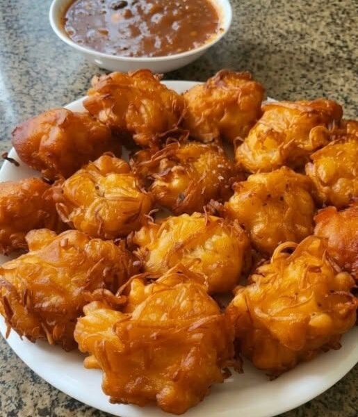 Homemade Amish onion fritters fried until crispy and golden brown and served with dipping sauce.