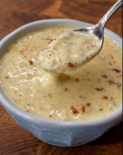 Creamy Canadian cheese soup with melted cheddar and crispy bacon pieces served in a bowl.