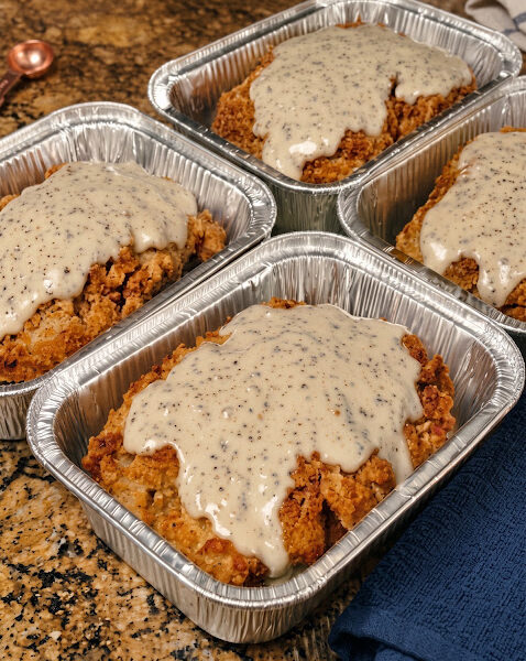 Southern chicken-fried steak with crispy golden breading topped with creamy black pepper gravy.